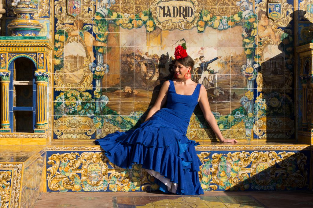 Mozaik csempés fal előtt ülő hölgy Madridban