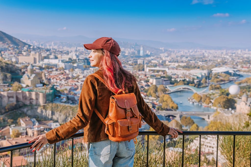Turista magaslati helyről tekint le egy grúz városra